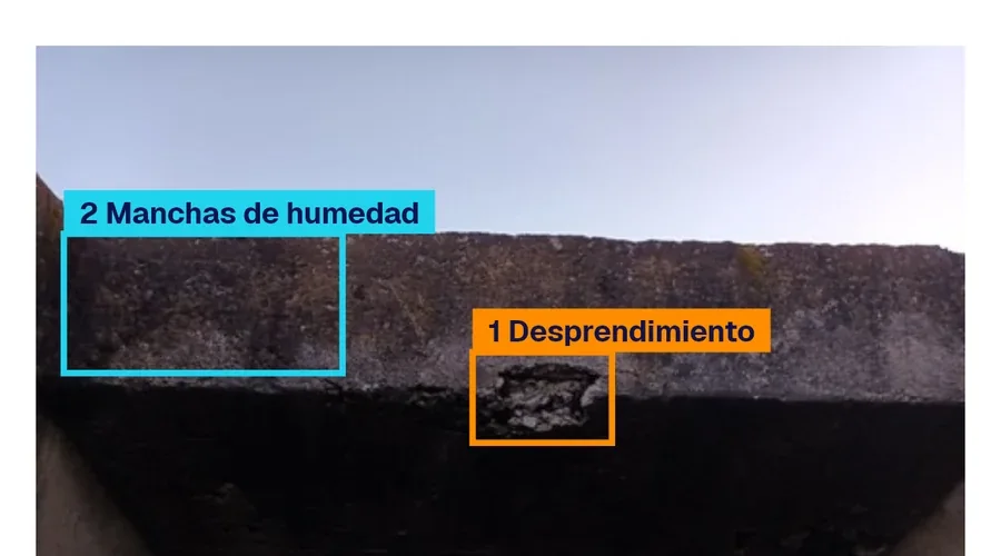 Foto de una losa con las marcas de la IA: dos manchas de humedad y un desprendimiento, cada uno en su recuadro.